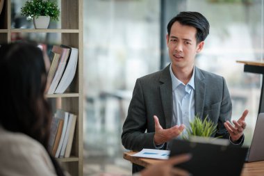 Ofiste masa başında çalışırken gülümseyen iki iş adamı. Yüksek kalite fotoğraf