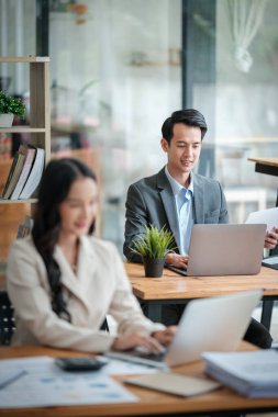 Ofiste masa başında çalışırken gülümseyen iki iş adamı. Yüksek kalite fotoğraf