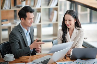 Ofiste masa başında çalışırken gülümseyen iki iş adamı. Yüksek kalite fotoğraf