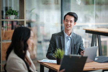 Ofiste masa başında çalışırken gülümseyen iki iş adamı. Yüksek kalite fotoğraf