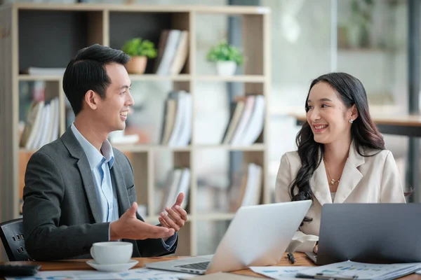Ofiste masa başında çalışırken gülümseyen iki iş adamı. Yüksek kalite fotoğraf