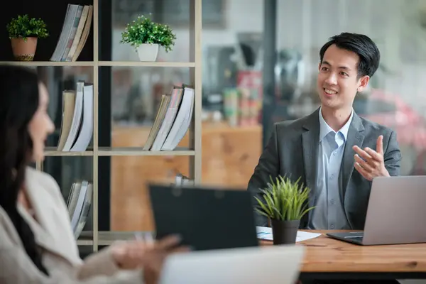 stock image Two business workers smiling happy working sitting on desk at the office. High quality photo