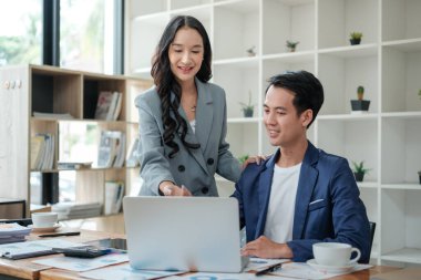 Ofiste masa başında çalışırken gülümseyen iki iş adamı. Yüksek kalite fotoğraf