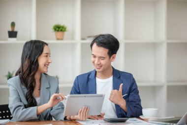 Ofiste masa başında çalışırken gülümseyen iki iş adamı. Yüksek kalite fotoğraf