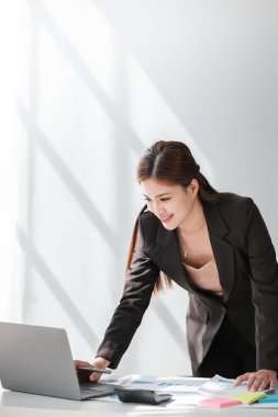 Asyalı İş kadını, bir ofis masası, vergi, rapor, muhasebe, istatistik ve analitik araştırma konseptinde matematik finansmanı için hesap makinesi ve dizüstü bilgisayar kullanıyor. Yüksek kalite fotoğraf