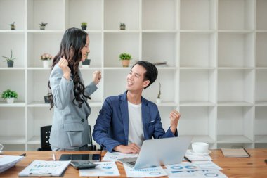 Ofiste masa başında çalışırken gülümseyen iki iş adamı. Yüksek kalite fotoğraf