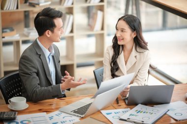 Ofiste masa başında çalışırken gülümseyen iki iş adamı. Yüksek kalite fotoğraf