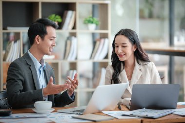 Ofiste masa başında çalışırken gülümseyen iki iş adamı. Yüksek kalite fotoğraf