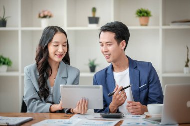 Ofiste masa başında çalışırken gülümseyen iki iş adamı. Yüksek kalite fotoğraf