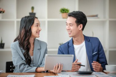 Ofiste masa başında çalışırken gülümseyen iki iş adamı. Yüksek kalite fotoğraf