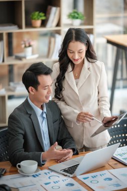 Ofiste masa başında çalışırken gülümseyen iki iş adamı. Yüksek kalite fotoğraf