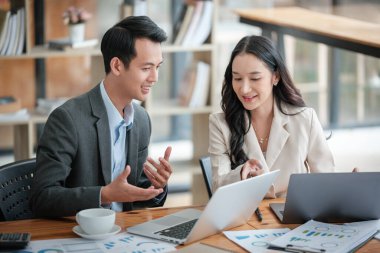 Ofiste masa başında çalışırken gülümseyen iki iş adamı. Yüksek kalite fotoğraf