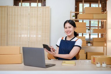 Küçük işletme girişimcisi ya da serbest çalışan bir Asyalı kadının bilgisayarı kutusu, genç başarılı Asyalı kadının el kaldırışı, online pazarlama kutusu ve teslimatı, KME konsepti. Yüksek