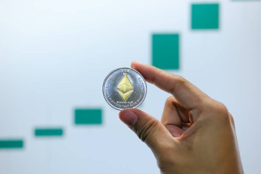 Dizüstü bilgisayarında yüksek fiyat grafiği arka planı, gelecekteki konsept finansal para birimi, kripto para birimi işareti olan bir madeni para sembolü. Yüksek kaliteli fotoğraf.