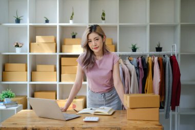 İş yerinde bir kutuyla çalışan genç Asyalı kadın KOBİ 'nin portresi. Küçük işletme sahibi, küçük işletme girişimcisi KOBİ veya serbest iş yeri çevrimiçi ve dağıtım konsepti. Yüksek
