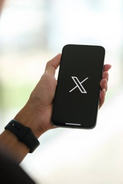 CHIANG MAI, THAILAND - Jul. 28,2023: Ekranda X ya da Twitter uygulaması olan iPhone 14 Pro Max tutan bir adam. Instagram popüler bir online sosyal ağ hizmetidir. Yüksek kalite fotoğraf