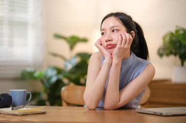 Asyalı üniversite öğrencileri evde dizüstü bilgisayarlarının başında oturup evdeki bir bilgisayar üzerinden internet üzerinden araştırma yaparak strese giriyorlar. Yüksek kaliteli fotoğraf..