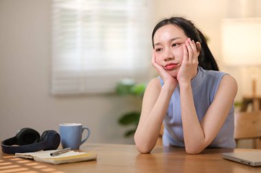 Asyalı üniversite öğrencileri evde dizüstü bilgisayarlarının başında oturup evdeki bir bilgisayar üzerinden internet üzerinden araştırma yaparak strese giriyorlar. Yüksek kaliteli fotoğraf..