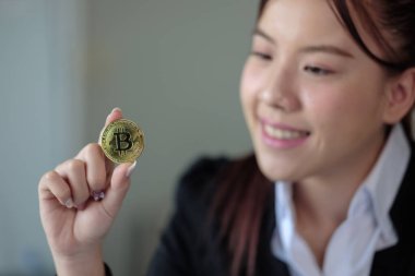 Business woman look at Bitcoin btc cryptocurrency as saving bank account currency in finance exchange trade for digital money gold technology cash. Person invest in electronic online payment market