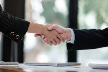 İş ortamında tokalaşan iki kişi. İki birey arasındaki profesyonellik ve güven kavramı