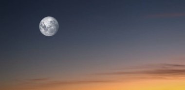 Full moon rising at sunset sky in autumn season.