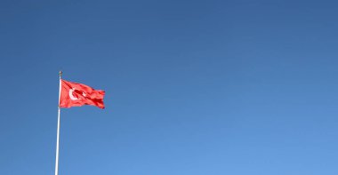 Turkish flag waving in a cloudless blue sky. Background image for Turkish national days.