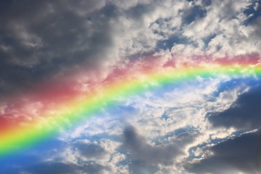 Rainbow among fluffy rain clouds.
