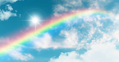 Rainbow and sun shining in blue sky. Nature background. Stretch ceiling decoration pattern