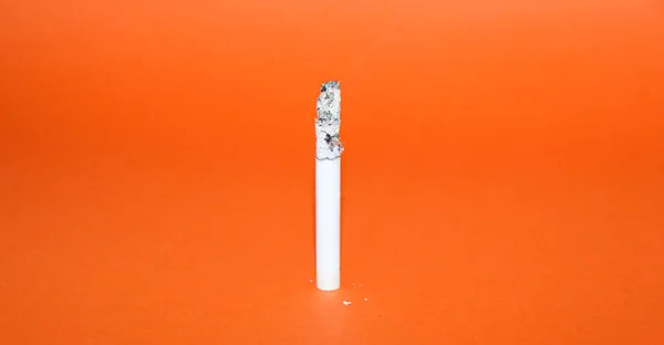 Eine Brennende Weiße Zigarette Auf Orangefarbenem Hintergrund — Stockfoto