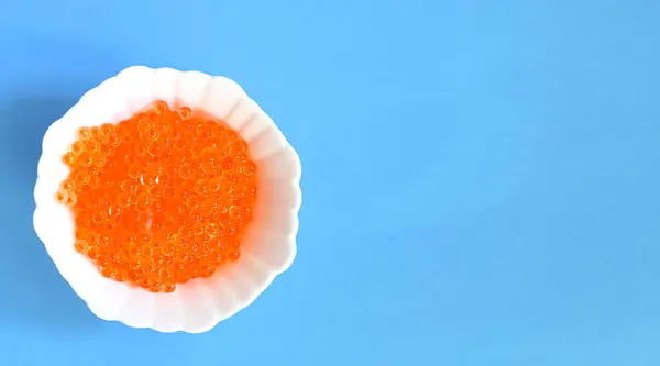 Red salmon caviar on a white plate. Caviar texture. Healthy seafood.