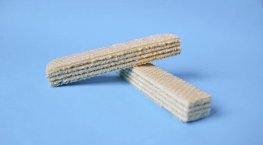 Açık mavi arka planda izole edilmiş beyaz gofretler. Sağlıksız ama lezzetli abur cubur..