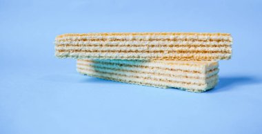 Açık mavi arka planda izole edilmiş beyaz gofretler. Sağlıksız ama lezzetli abur cubur..