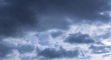 Kasvetli gökyüzü. Yağmur ve fırtına bulutları gökyüzünü tamamen kaplıyor. Karanlık gökyüzünün dipteki görüntüsü.