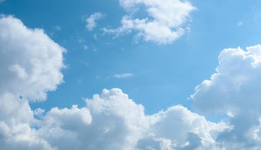 Bahar mevsiminde açık mavi gökyüzünde beyaz kabarık bulutlar. Aşağıdaki mavi gökyüzü bulutlu.