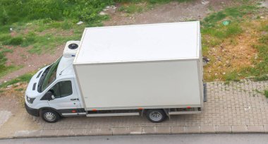 Park ihlali. Kaldırıma park edilmiş beyaz arabanın üst görüntüsü.. 