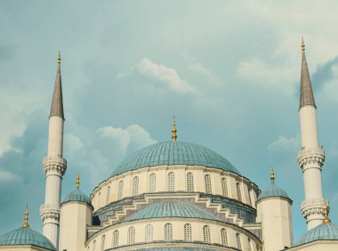 Tarihi cami kubbesi, minareler ve bulutlu gökyüzü. Cami manzarası. İslami arkaplan. Dışarıdaki tapınak inşaatı.