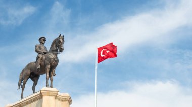 Turkish flag waving in the sky and Ataturk statue. Mustafa Kemal Ataturk monument and Turkish flag on beautiful blue sky background. clipart