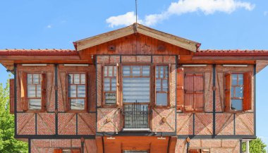 Osmanlı mimarisi ile inşa edilmiş eski bir malikane. Ahşap panjurları ve tuğlaları olan restore edilmiş eski bir evin ön manzarası..