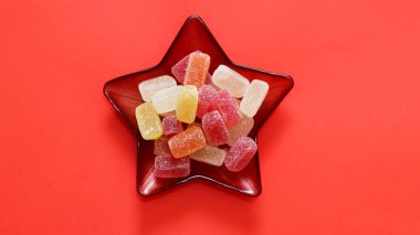 Tatil şekerleri. Renkli meyve aromalı şekerler. Yıldız şeklinde kırmızı cam şeker kasesinde Türk lezzetleri.