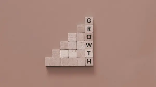 Büyüme konsepti arkaplan resmi. Büyüme kelimesi tahta küplere yazılmıştır..