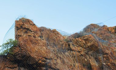 Kayalar düşmesini önlemek için tel örgüyle bağlanmış..