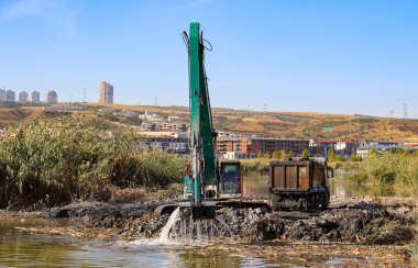 A construction machine and big truck cleaning the water channel clipart