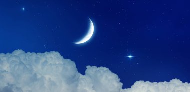 Hilal ve yıldızlar kabarık bulutların üzerinde parlıyor. Koyu mavi gece gökyüzü manzarası