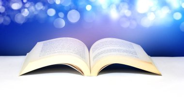 Mavi Bokeh ışıkları altında açık sayfaları olan kitap