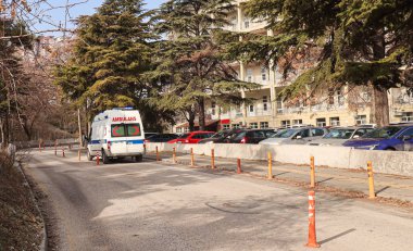Hastanenin önündeki yolda bekleyen ambulansın arka görüntüsü.