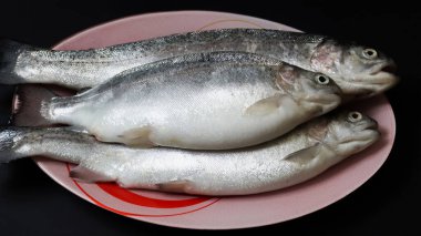 Siyah arka planda taze taze çiğ balık