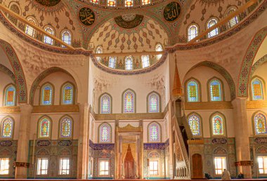 Ankara Kocatepe Camii - Çok renkli cam pencereler, kubbe, iç duvarlar ve İslami motiflerle dekorasyonlar.