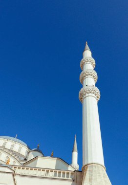 Cami kubbesi, beyaz minare ve mavi gökyüzü. Metin için boş alan. İslami kutsal gece ve günleri kutlamak için dikey resim