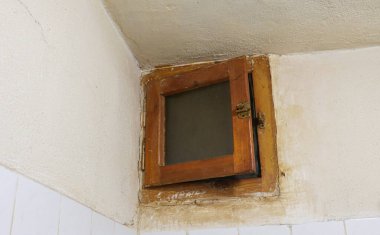 Banyo duvarındaki havalandırmayı kapatın. Tahta işlemeli havalandırma ızgarası, kirlenmiş evin havalandırma sisteminin bir parçası..