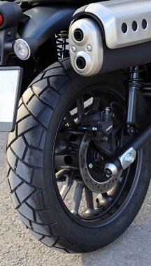 Motosikletin arka görüntüsü. Arka tekerlek, egzoz ve siyah bir motosikletin fren pedleri.. 